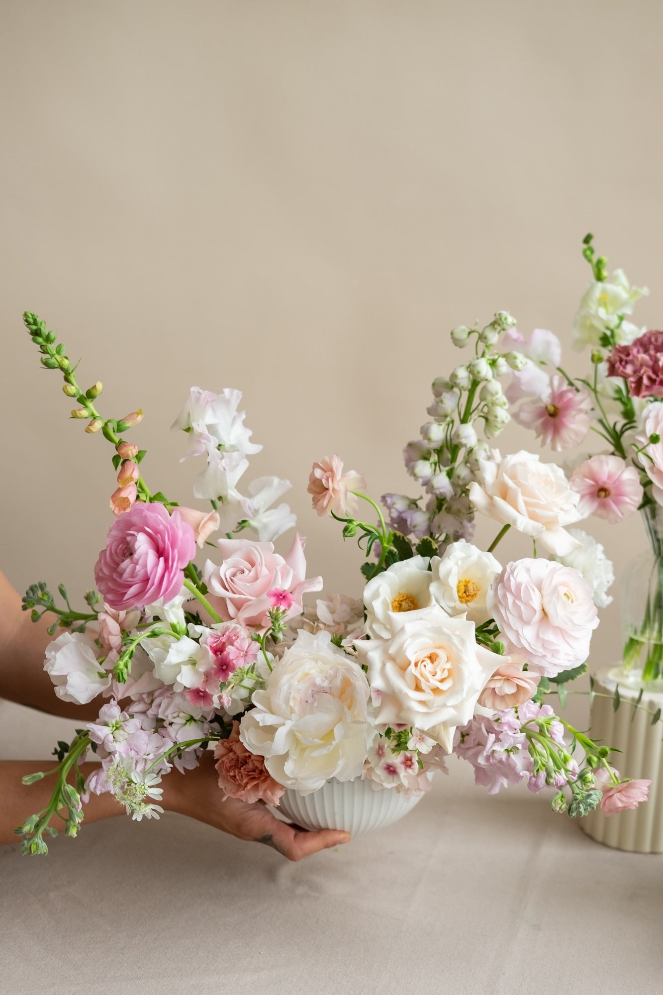 Bouquets of flowers in white, pink, and green on a neutral background