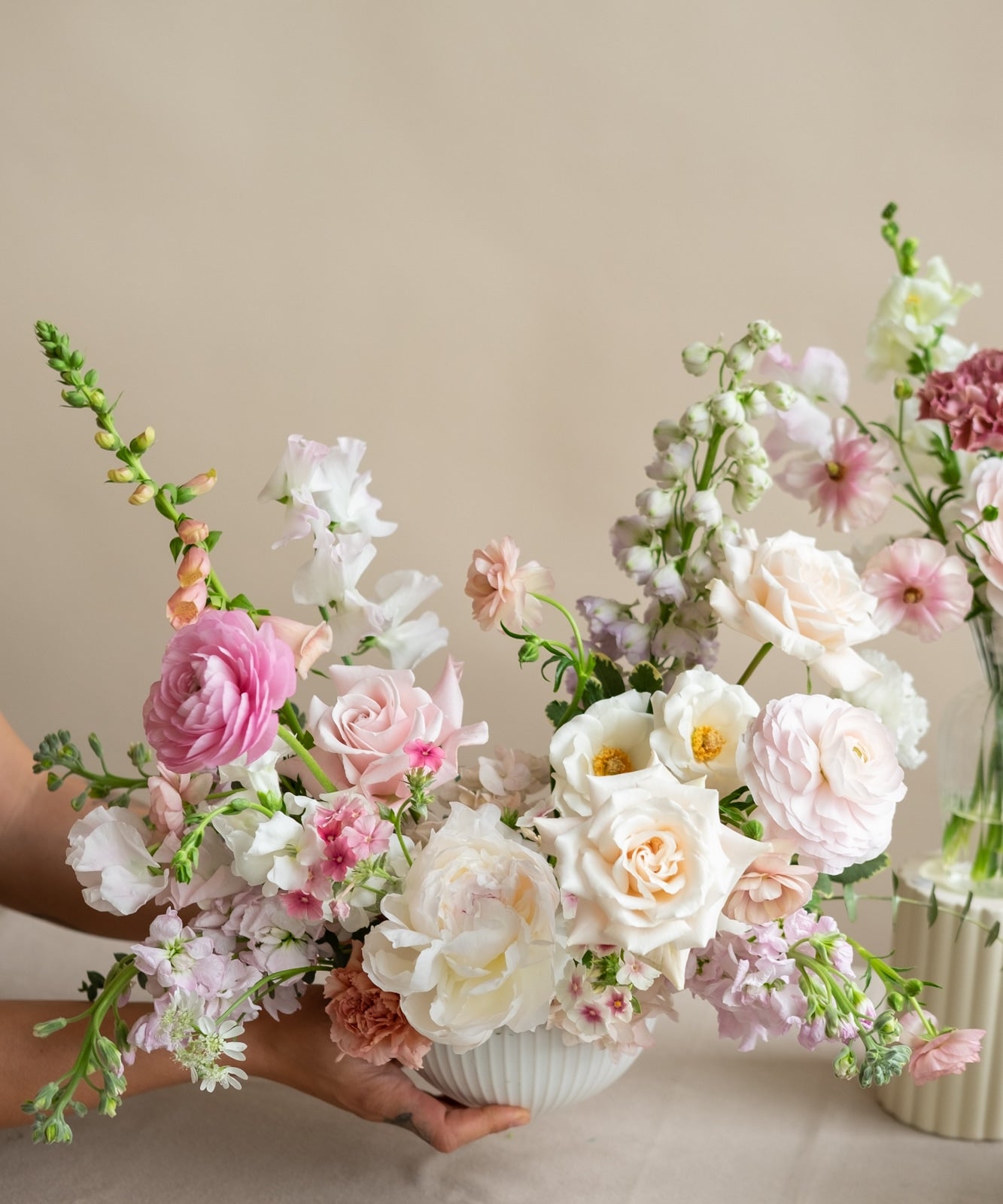 Bouquets of flowers in white, pink, and green on a neutral background